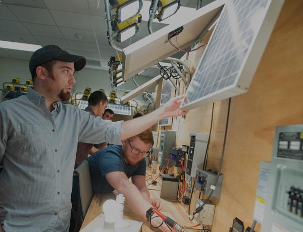 A student inspects a solar pannel during class.